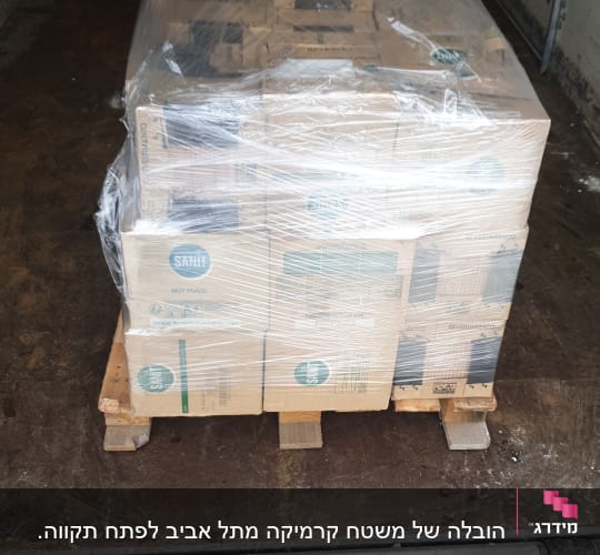 משטח עץ עם קרטונים עטופים בניילון שקוף